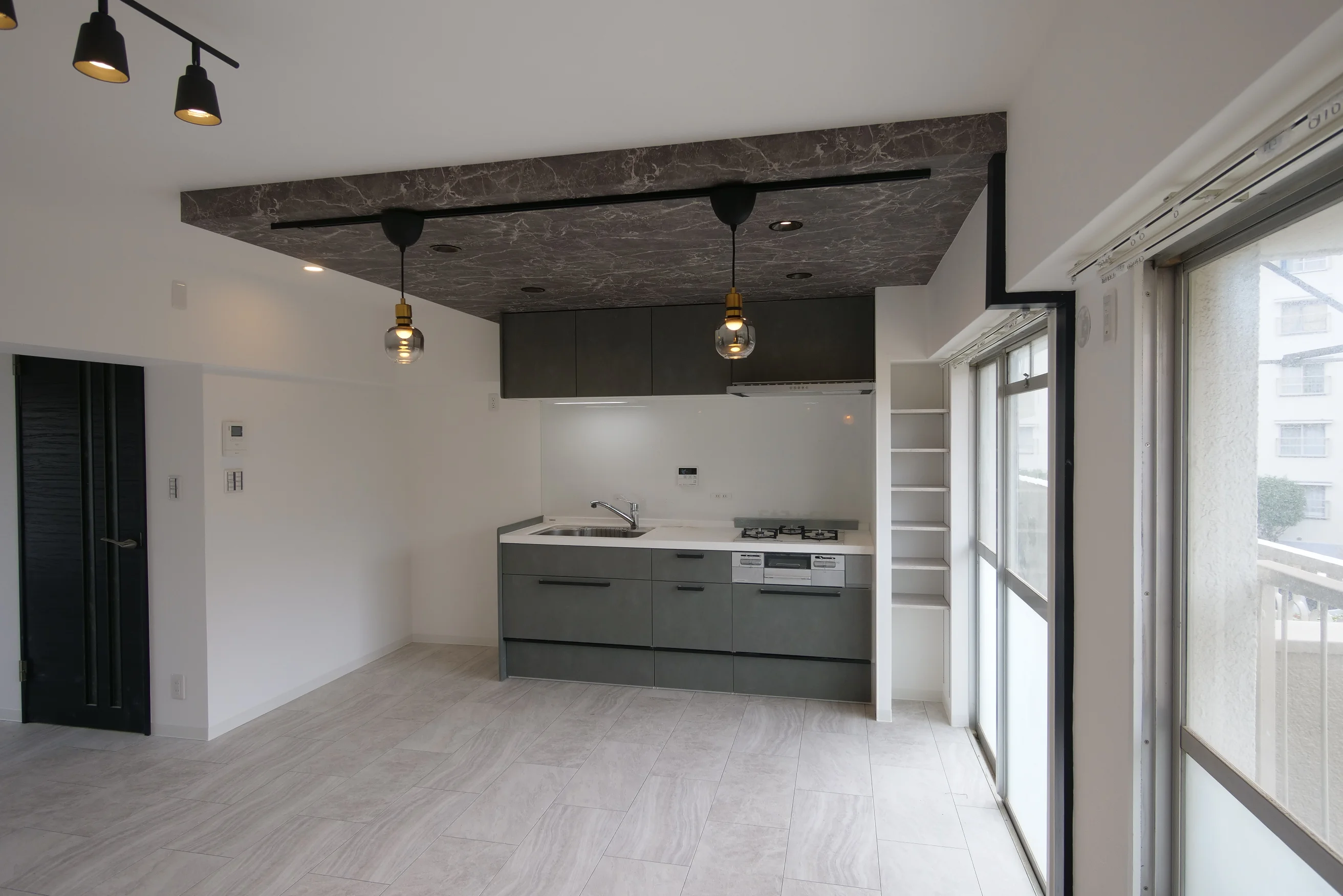 白や灰色を基調としたモダンなキッチンのある部屋